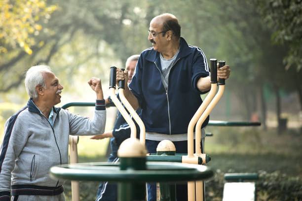 istock Friend motivating man exercising on cross trainer 1455264525