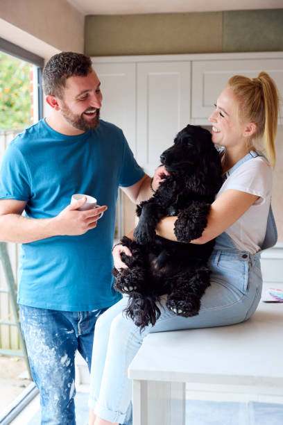 istock Couple On Coffee Break From Renovating Kitchen At Home Playing With Pet Spaniel Dog 1455265271