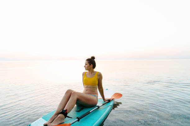 istock Young woman relaxing on a paddle board 1455266294
