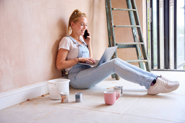 istock Woman Renovating Kitchen At Home Sits On Floor With Laptop Taking A Break From Decorating Kitchen 1455266521
