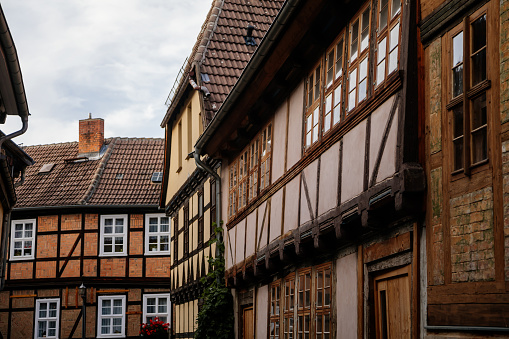 Quedlinburg, Saxony-Anhalt, Germany, 28 October 2022: Historic old vintage colored timber frame houses in medieval town, UNESCO World Heritage city, half-timbered home at sunny autumn day, cobblestone