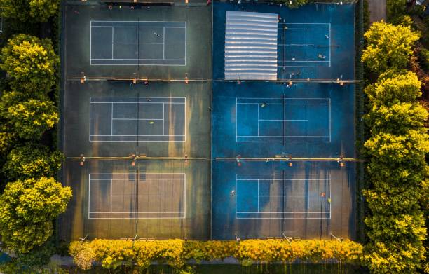 istock Drone shot over six tennis courts with forest trees around 1455268056