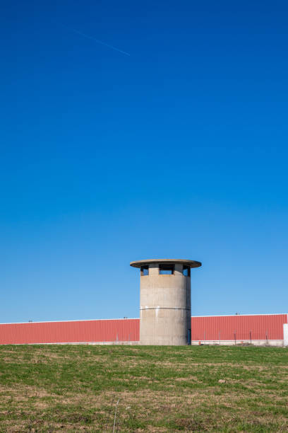 istock factory building seen from afar with a watchtower and blue sky in the background 1455268936
