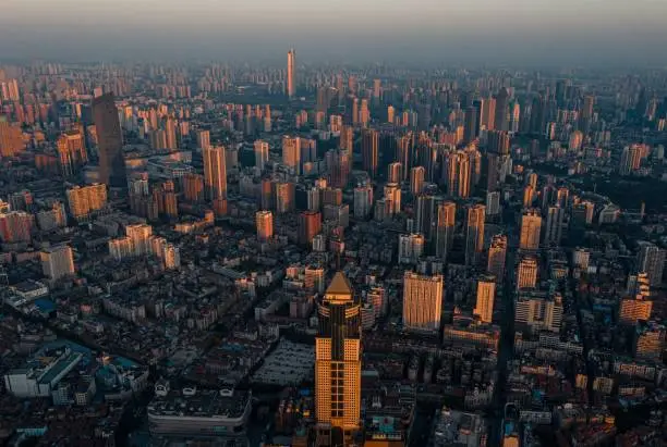 A cityscape of Wuhan city skyscrapers with foggy sky at sunset in China
