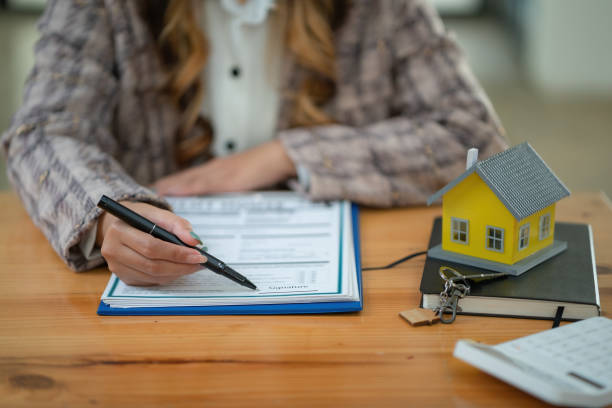 Sale purchase contract to buy a house, Real estate agents are presenting a home loan and give keys to a customer after signing the contract to buy a house with an approved property application form. contrato de compraventa para comprar una casa, los agentes inmobiliarios están presentando un préstamo hipotecario y entregan llaves a un cliente después de firmar el contrato para comprar una casa con un formulario de solicitud de propiedad aprobado.