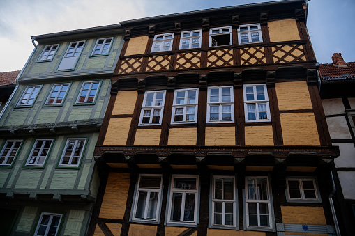 Quedlinburg, Saxony-Anhalt, Germany, 28 October 2022: Historic old vintage colored timber frame houses in medieval town, UNESCO World Heritage city, half-timbered home at sunny autumn day, cobblestone