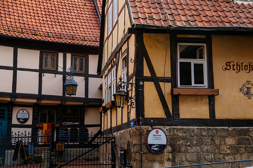 Quedlinburg, Saxony-Anhalt, Germany, 29 October 2022: Historic old vintage colored timber frame houses in medieval town, UNESCO World Heritage city, half-timbered home at sunny autumn day, cobblestone