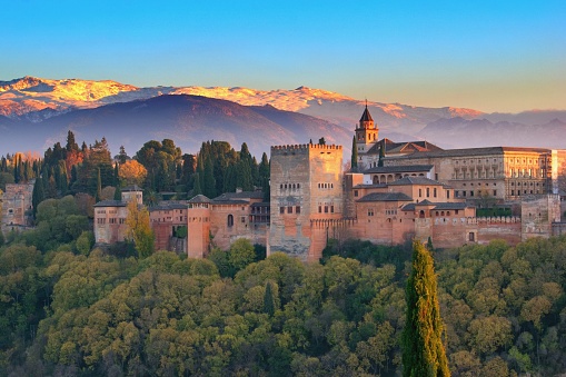 Panoramic view of The Alhambra in Granada at sunset with Sierra Nevada mountains in the Background. Andalusia, southern of Spain
