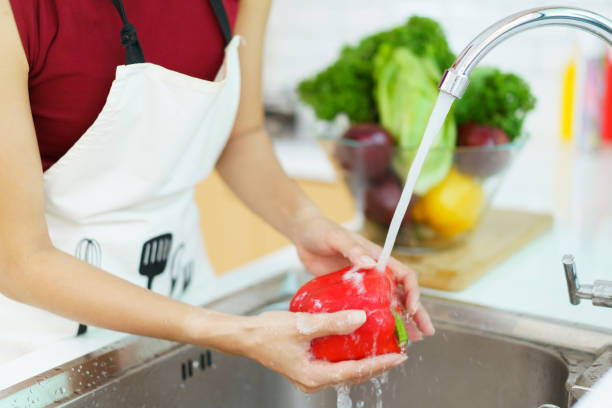 istock Woman washing a vegetable. 1455273230