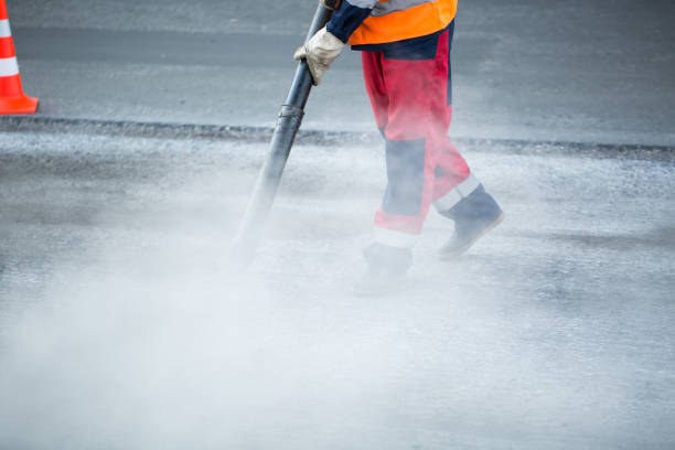 istock Worker with leaf-blower, cleaning out the dust for better asphalt adhesion, during tram track renewal works 1455273917