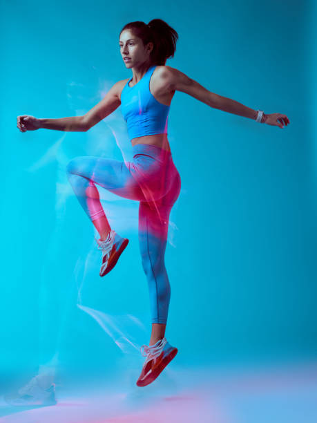 istock A fit sportswoman jumping and doing exercises. Long exposure capture movement. 1455275104