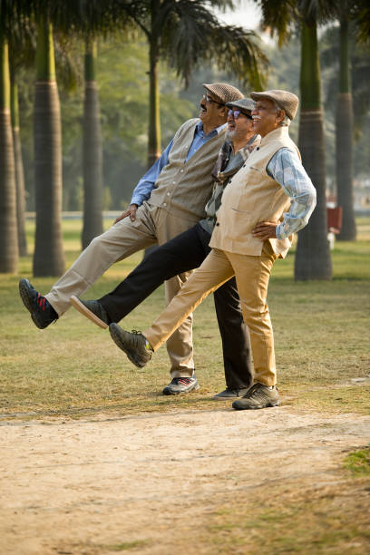 Cheerful old male friends spending leisure time at park
