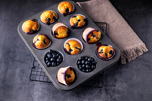 Homemade blueberry muffins in baking mold .