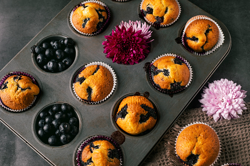 Homemade blueberry muffins in baking mold .Flower decoration