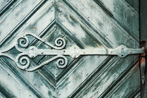 Old, grey-blue church door with ironwork in Lund, Sweden. Close-up