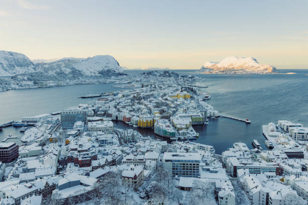 Scenic aerial view of Alesund city in snow by the sea during scenic sunset in Norway stock photo