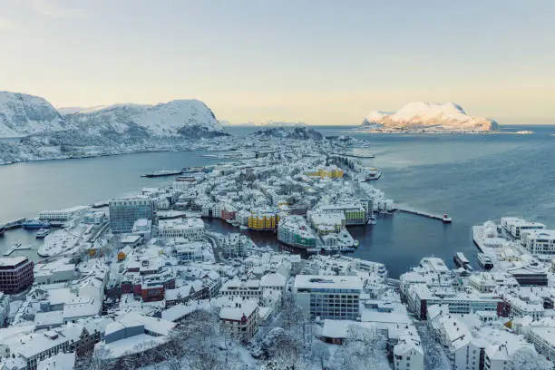 High-angle photo of Ålesund city with view of the beautiful mountain peaks and the ocean during winter time
