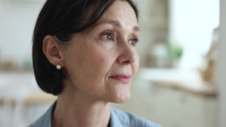 Close up face of pensive serious middle-aged woman