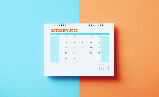 October 2023 calendar on blue and orange background. Directly above. Horizontal composition with copy space. Calendar and reminder concept.