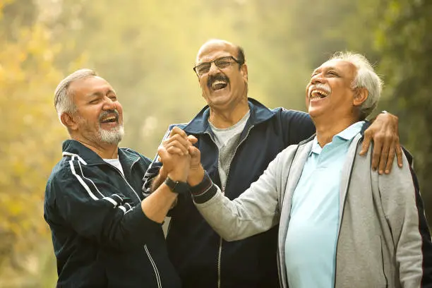 Photo of Old male friends laughing at park