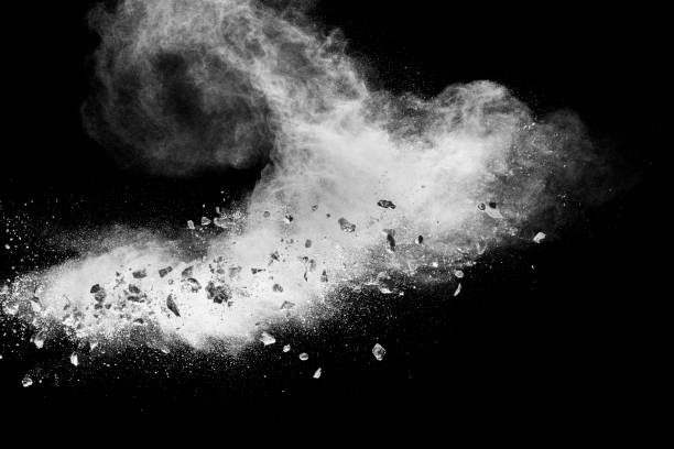 istock White powder with small stones on black background. Small granite rock stone fly on dust against dark background. 1455284734