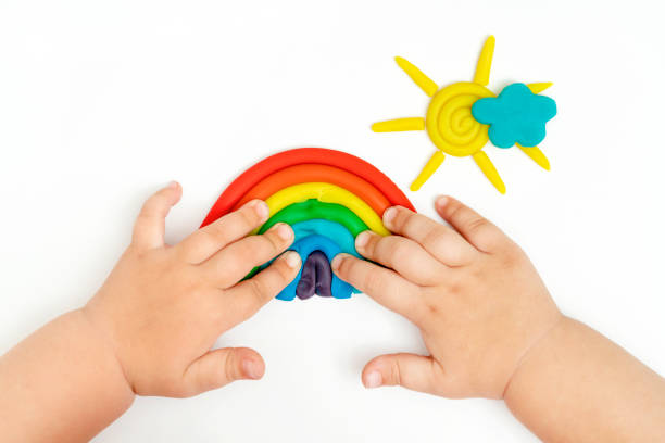 istock Baby hands making rainbow, cloud, sun with rays from modeling clay. Toddler development. 1455284978