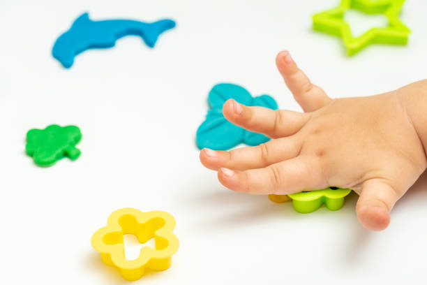 istock Baby hand playing with colorful play dough or plasticine. 1455285007