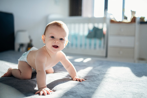 Portrait of cute crawling baby boy.