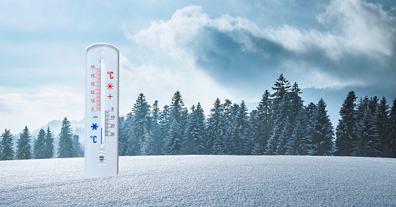 Thermometer with minus temperatures in snow in winter