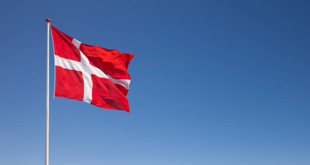 istock Danish national flag waving in the wind against blue sky 1455286018