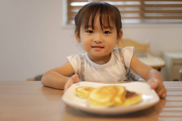 istock girl eating hot cake 1455287647