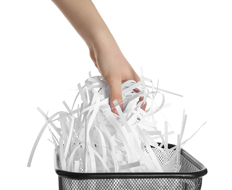 Tax form 1040 for 2020 ready to be shredded. Closeup of IRS form 1040 with shredded pile of paper in view. Shredding of documents are often completed to ensure security and prevent identity theft. Concept could be used to depict hoping to forget the difficult year of 2020.