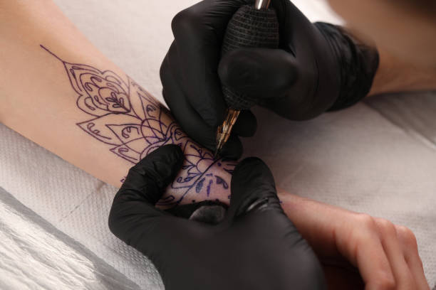 istock Professional artist making tattoo on hand at table, closeup 1455290371