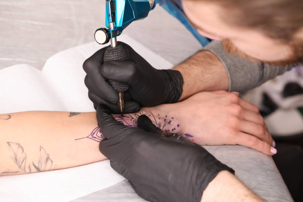 istock Professional artist making tattoo on hand at table, closeup 1455290391