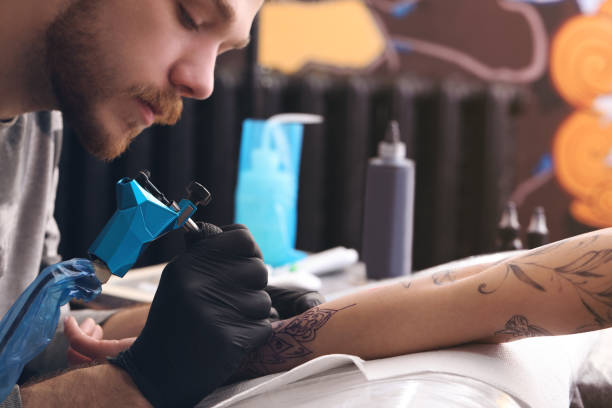 artista professionista che fa tatuaggio a portata di mano nel salone, primo piano - tatuare foto e immagini stock