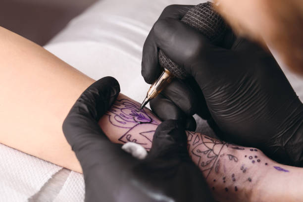istock Professional artist making tattoo on hand at table, closeup 1455290585