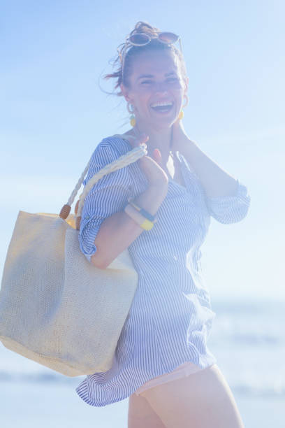 istock smiling elegant woman having fun time at beach 1455291086