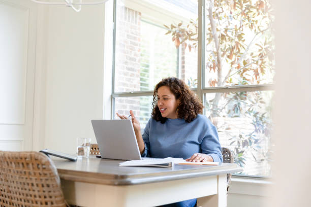 istock Mid adult woman gestures while explaining investment options to remote client 1455291846