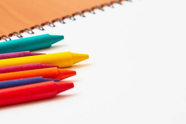 Cluster of brightly colored crayons on paper.