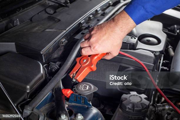 Mechanic Is Connecting A Boostercable To The Battery In Order To Jumpstart A Car Stock Photo - Download Image Now