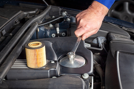 Mechanic is preparing an oil filter change at a modern car engine