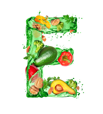 Latin letter E made of green splashes with food ingredients isolated on a white background (Vitamin E)