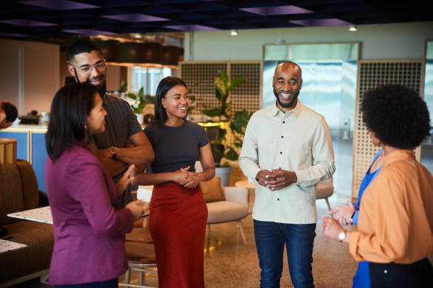 istock Smiling group of diverse businesspeople talking in an office lounge 1455296492