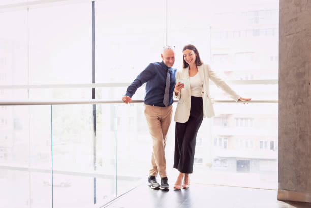 istock Group of business people working together while standing in a modern office corridor 1455296592