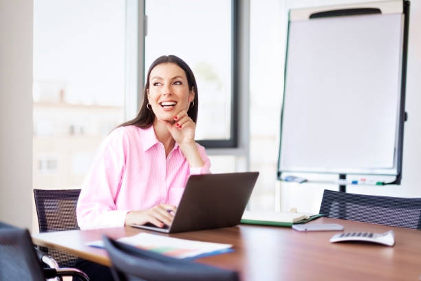 istock Attractive businesswoman sitting at office desk and using laptop for work 1455296643