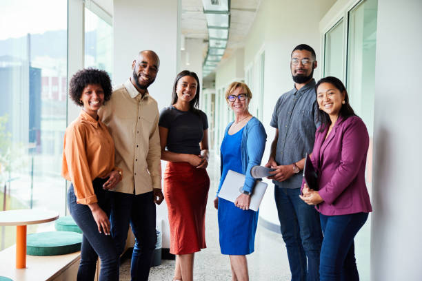 istock Smiling businesspeople standing together in an office hallway 1455296686
