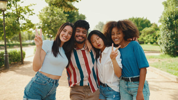 istock Happy, lovely multiethnic young people posing for the camera on summer day outdoors. group of friends hugging each other smiling at the camera while standing on path in the park 1455298548