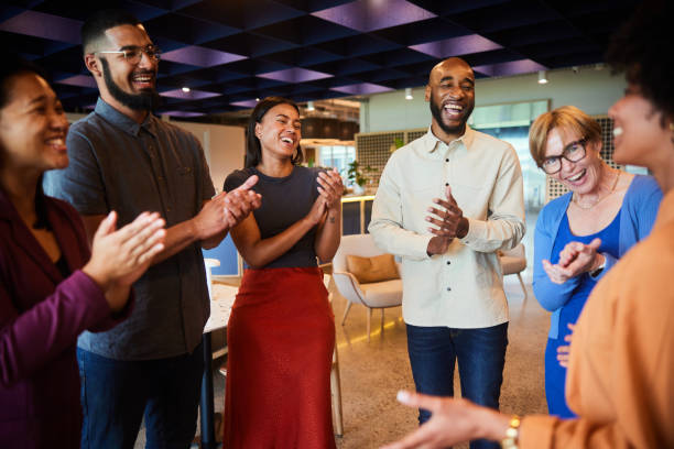 istock Laughing businesspeople clapping for a colleagues in an office lounge 1455298698