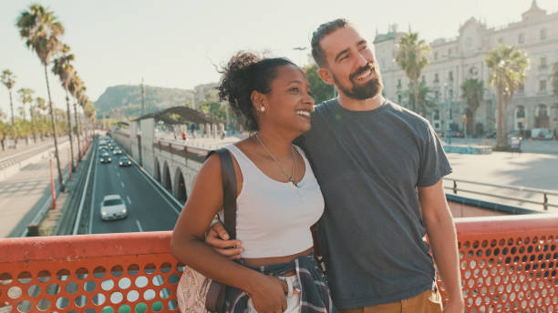 istock Close-up of happy interracial couple talking while standing on bridge 1455299859