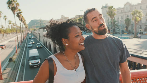 istock Close-up of happy interracial couple talking while standing on bridge 1455299870